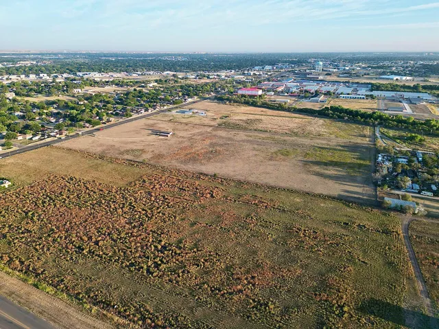 an aerial view of ocean and residential houses with outdoor space