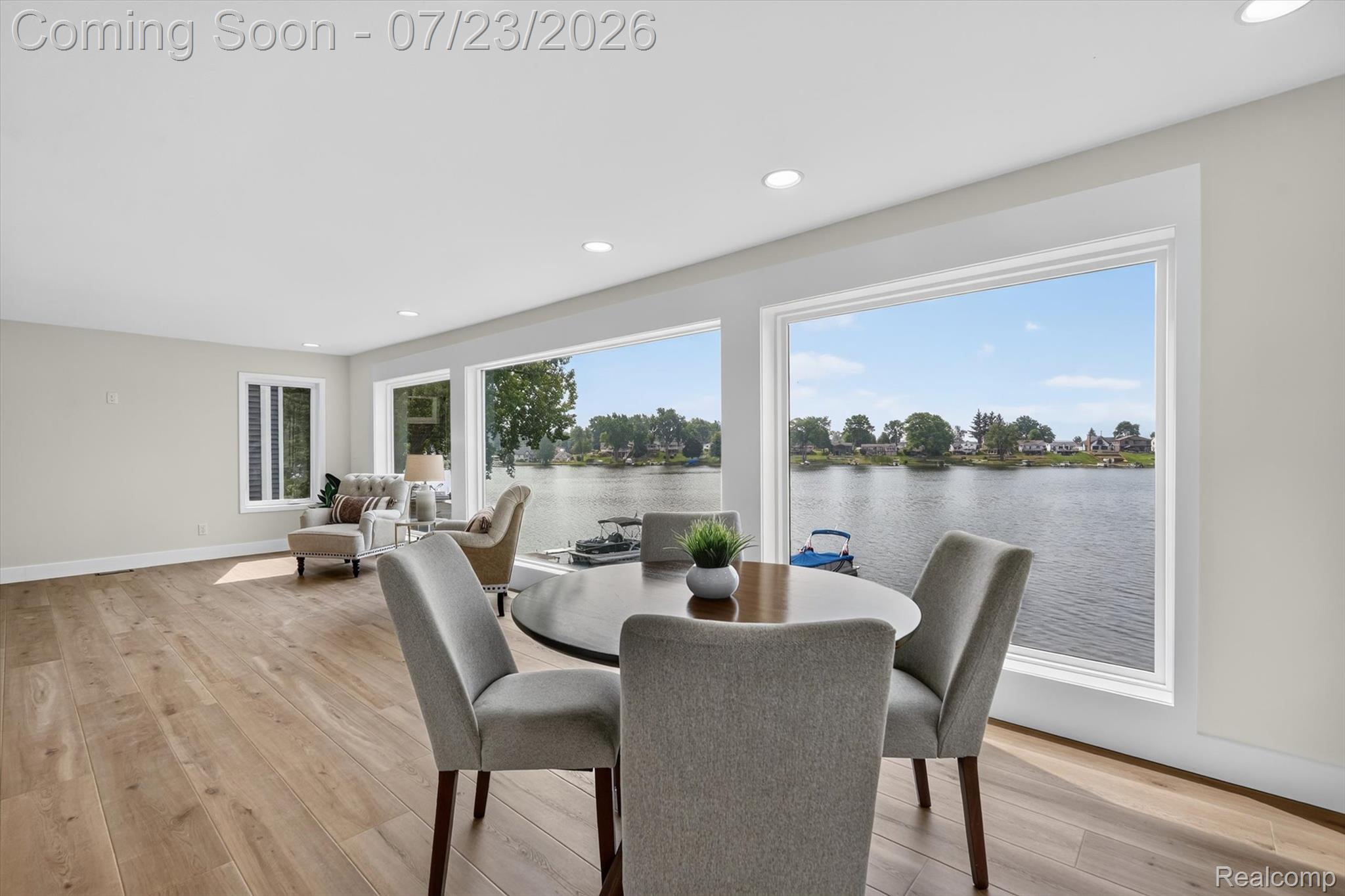 3429 Rolston Road Fenton, MI 48430 - Photo 12 of 62 Spacious room featuring expansive windows with water frontage, wood-finish flooring, recessed lighting, and a neutral color palette