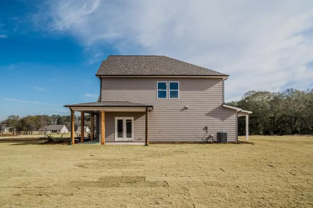 a front view of house with yard and trees in the background