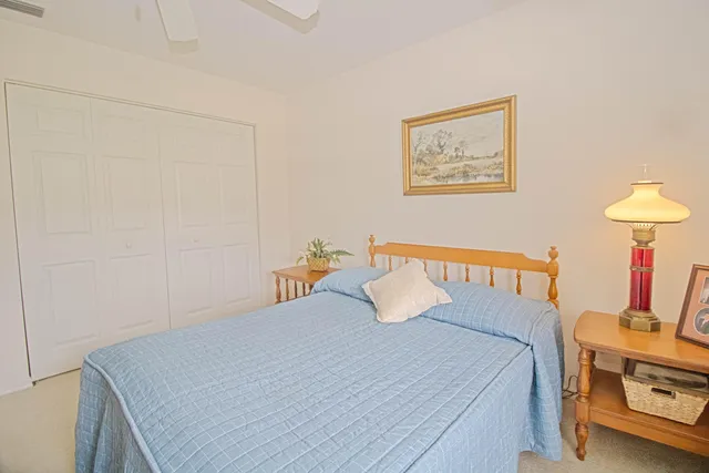 a bedroom with a bed and a lamp on the dresser