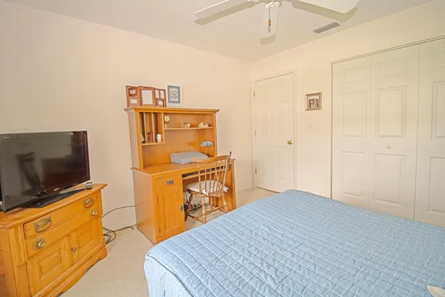 a bedroom with a bed and flat tv screen on the dresser