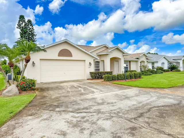 a front view of a house with a garden and yard