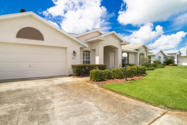 a view of a white house next to a yard