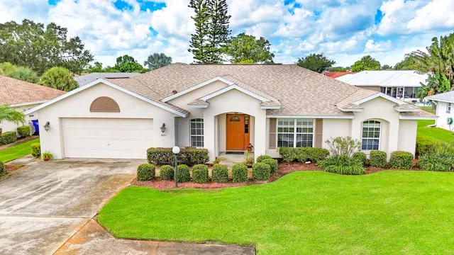 a front view of a house with a garden and plants