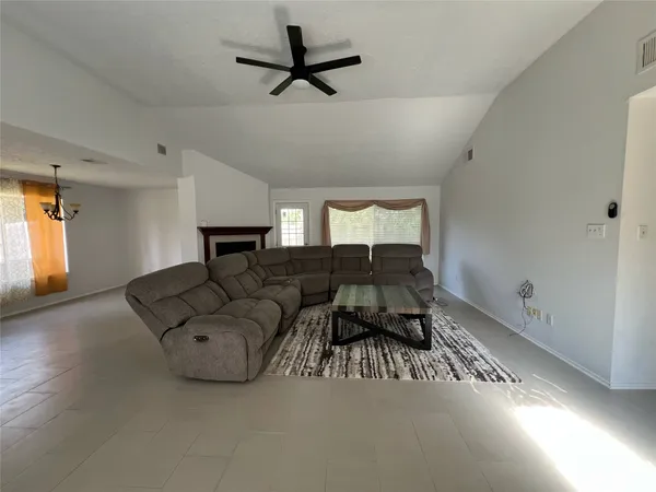 a living room with furniture and a ceiling fan