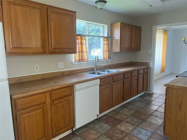 a kitchen with stainless steel appliances granite countertop a sink window and cabinets