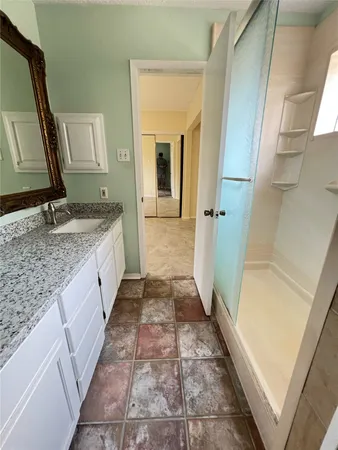 a bathroom with a granite countertop sink and a mirror