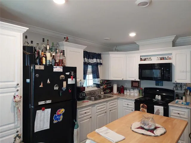 a living room with couches and kitchen view with wooden floor