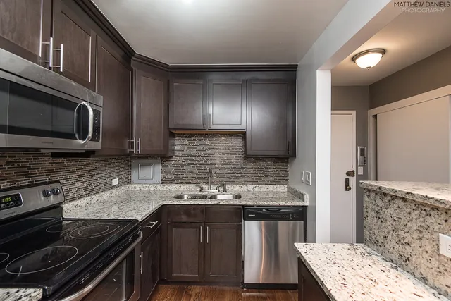 a kitchen with stainless steel appliances granite countertop a stove and a microwave