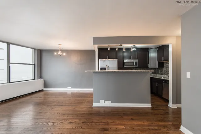 a view of kitchen with stainless steel appliances granite countertop refrigerator sink and cabinets
