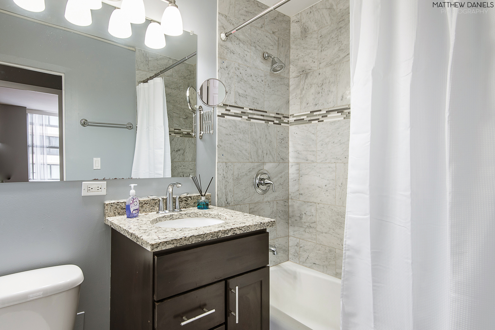 5757 North Sheridan Road, Unit 8C Chicago, IL 60660 - Photo 15 of 15 a bathroom with a granite countertop sink toilet and shower