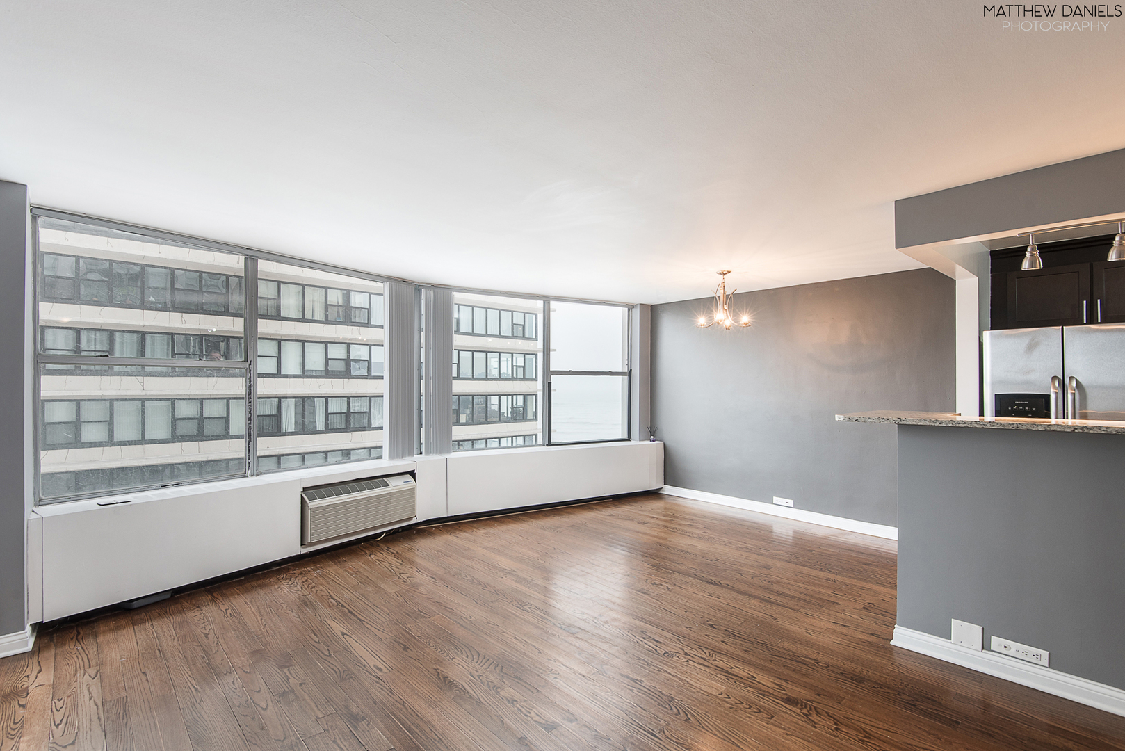 5757 North Sheridan Road, Unit 8C Chicago, IL 60660 - Photo 6 of 15 a view of an empty room with a window and wooden floor