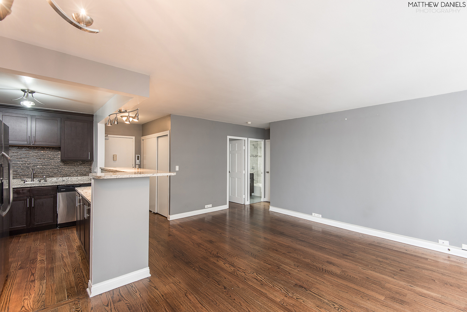 5757 North Sheridan Road, Unit 8C Chicago, IL 60660 - Photo 9 of 15 a big room with wooden floor and kitchen view