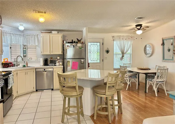 a kitchen with a dining table chairs and white cabinets