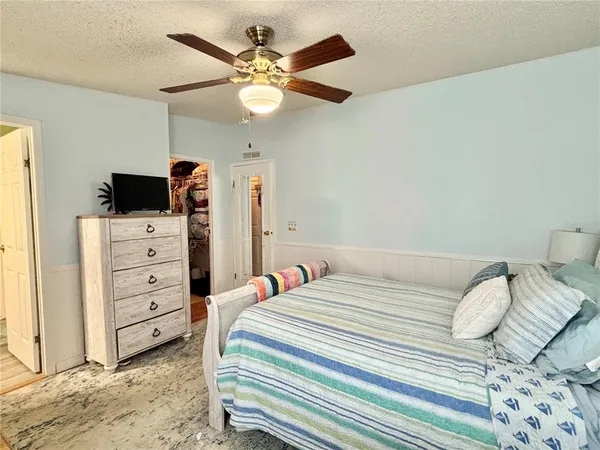 a bedroom with a bed and a flat tv screen on dresser