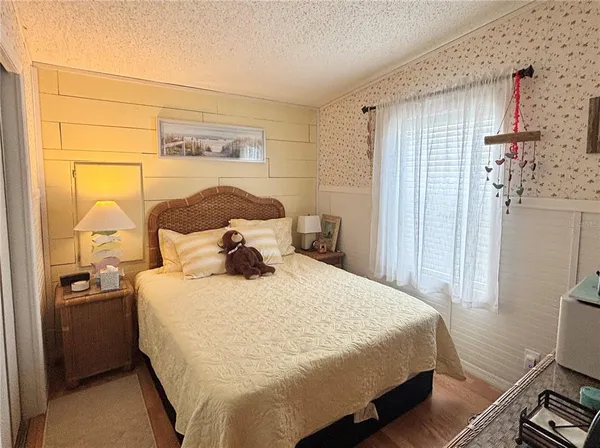 a bedroom with a bed and wooden floor