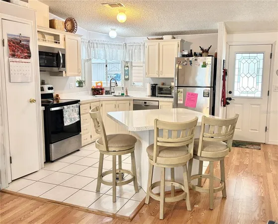 a kitchen with stainless steel appliances kitchen island granite countertop a refrigerator and microwave