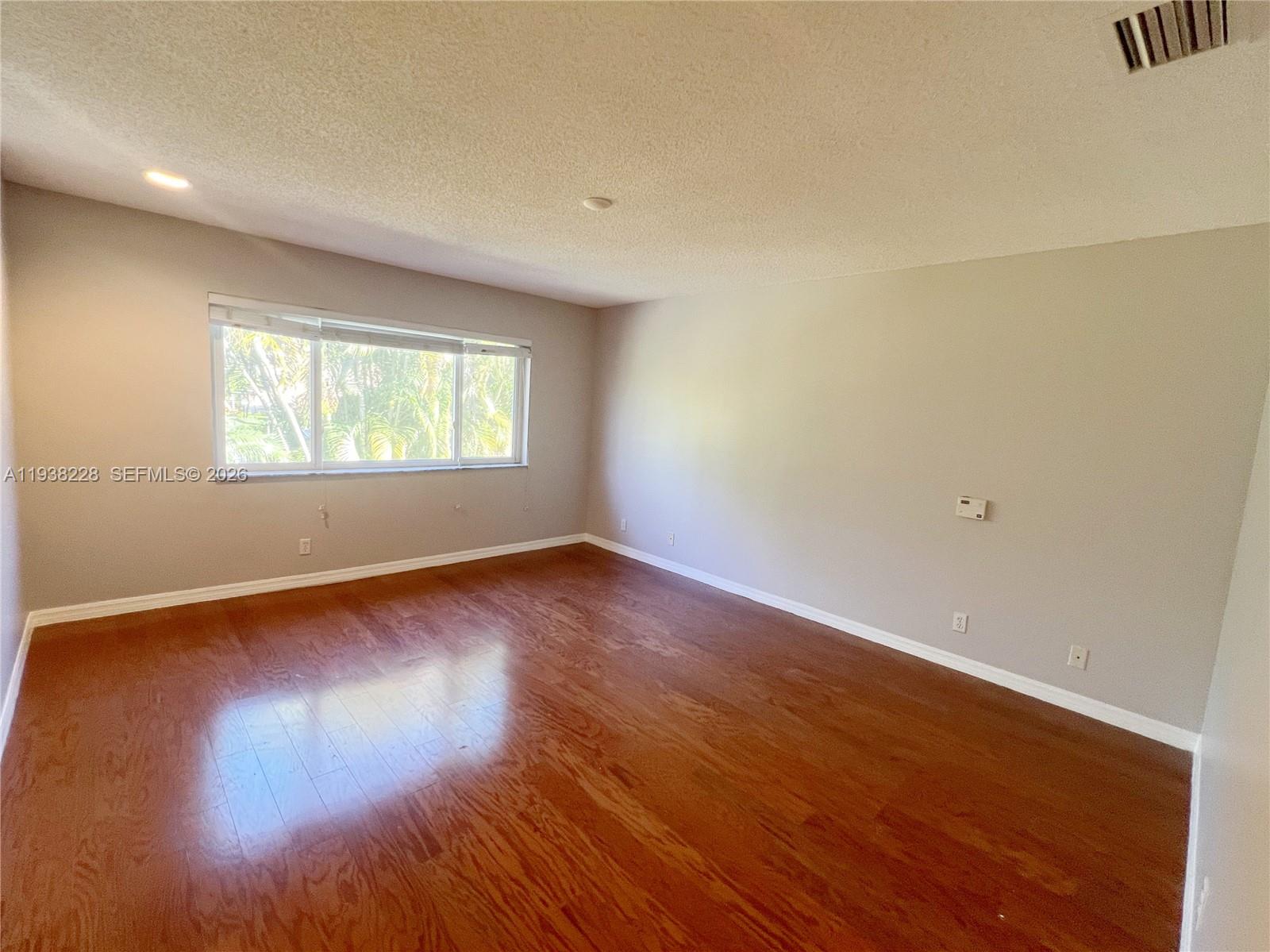 15827 Southwest 12th Street Pembroke Pines, FL 33027 - Photo 12 of 24 an empty room with wooden floor and windows