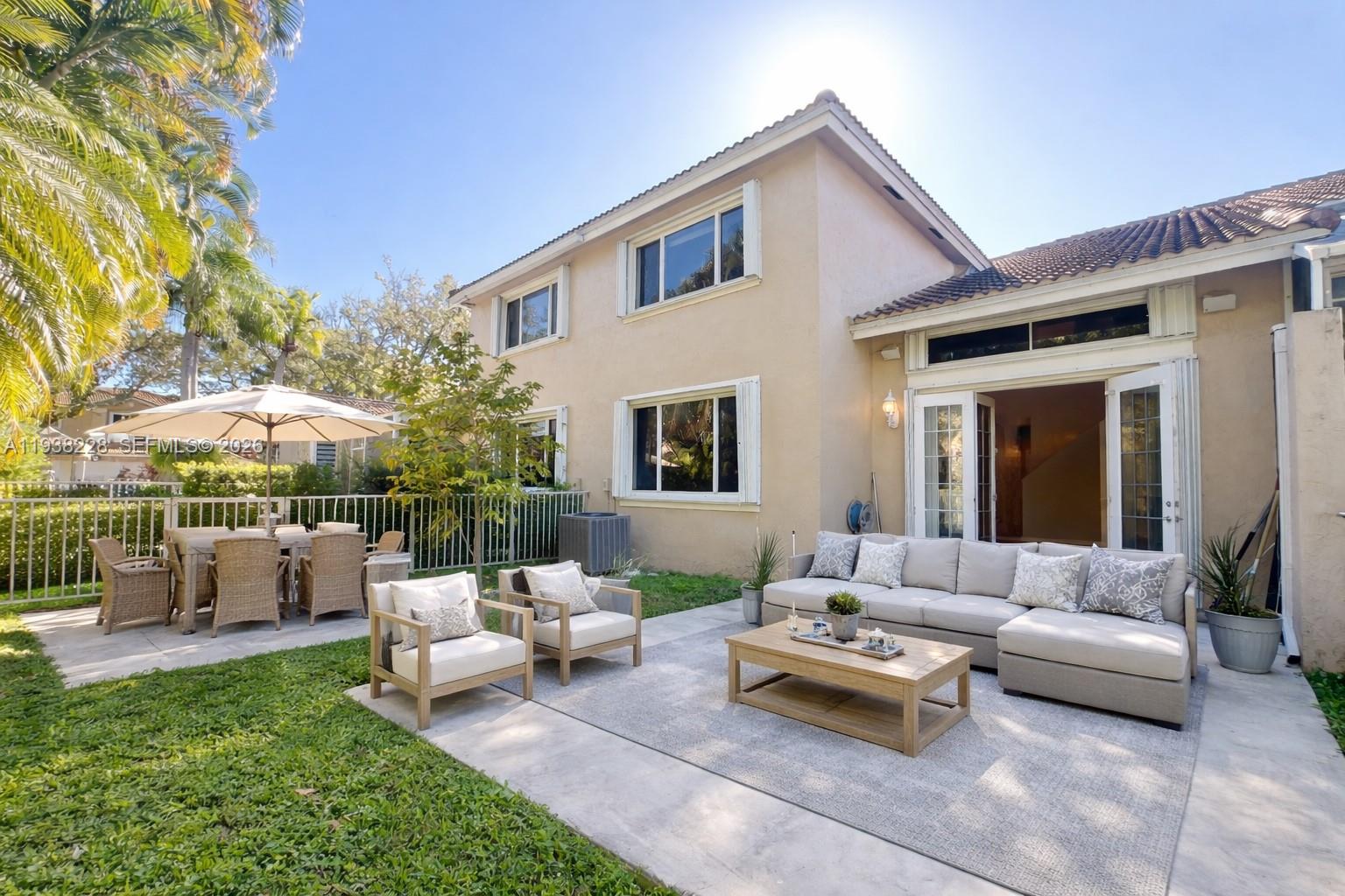 15827 Southwest 12th Street Pembroke Pines, FL 33027 - Photo 23 of 24 a view of a patio with couches and table and chairs under an umbrella