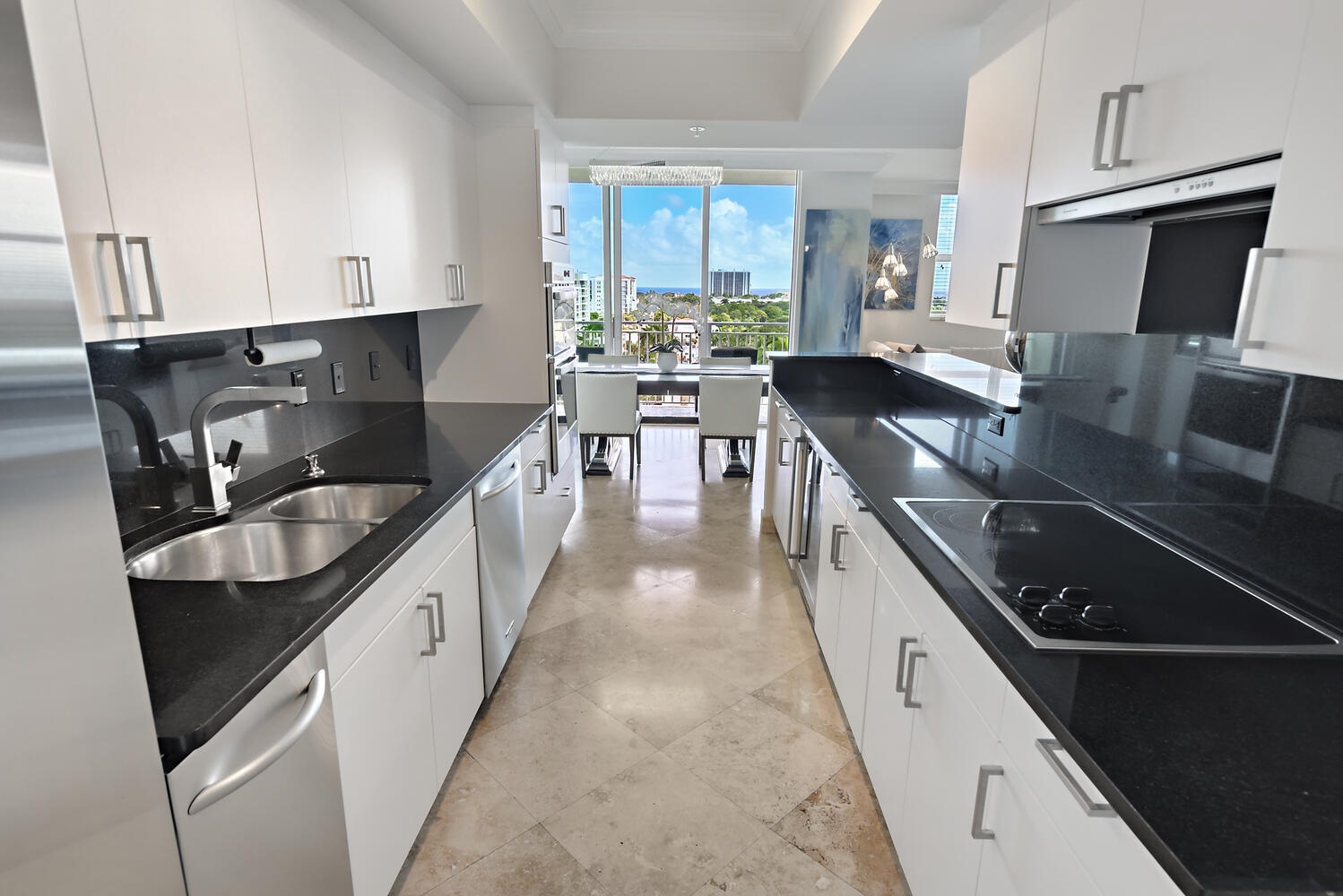 99 Southeast Mizner Boulevard, Unit PH 909 Boca Raton, FL 33432 - Photo 8 of 51 a kitchen with kitchen island granite countertop a sink appliances cabinets and a counter top space