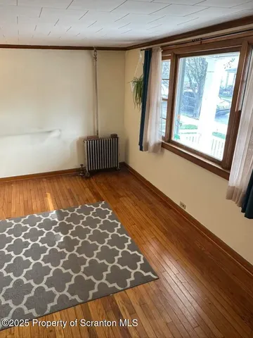 a view of wooden floor and a window in a room