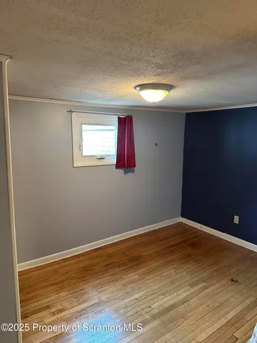 a view of a room with wooden floor and a window