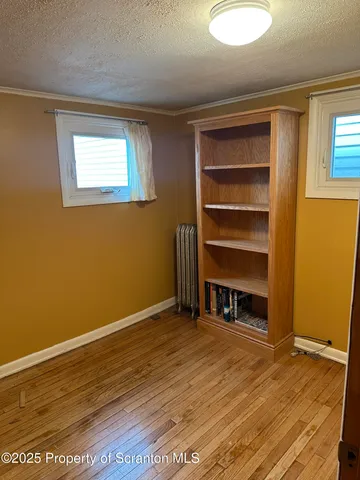 a view of a room with a wooden floor and a window