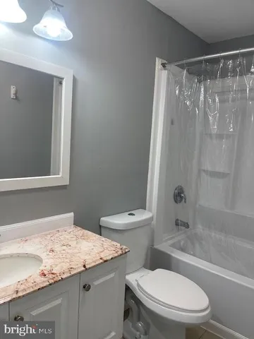 a bathroom with a granite countertop toilet sink and shower