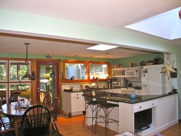 a kitchen with stainless steel appliances wooden floor dining table and chairs