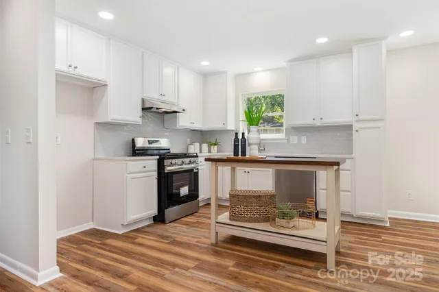 a kitchen with kitchen island granite countertop a stove a refrigerator and a sink