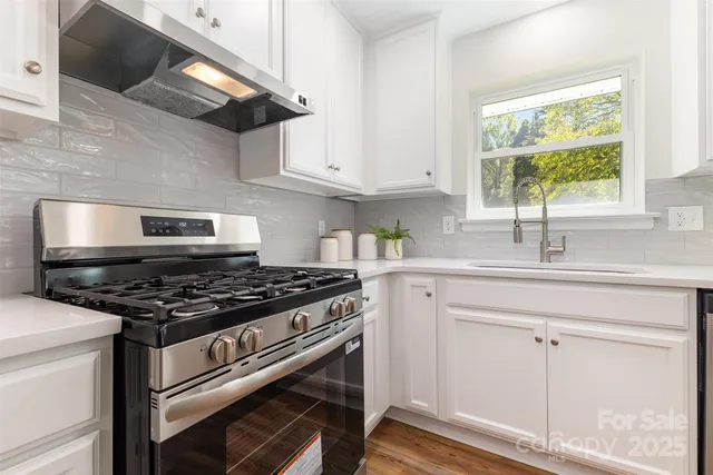 a kitchen with white cabinets and a stove top oven