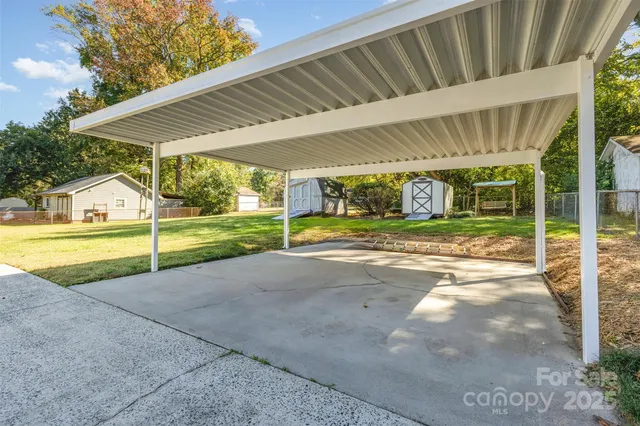 a view of a house with a big yard and large tree