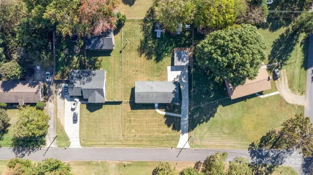 an aerial view of a house with a yard swimming pool and outdoor seating