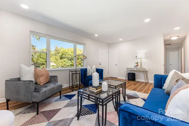 a living room with furniture a fireplace and a large window