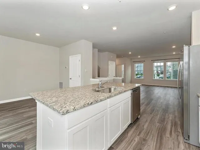 a bathroom with a granite countertop sink and a wooden floor