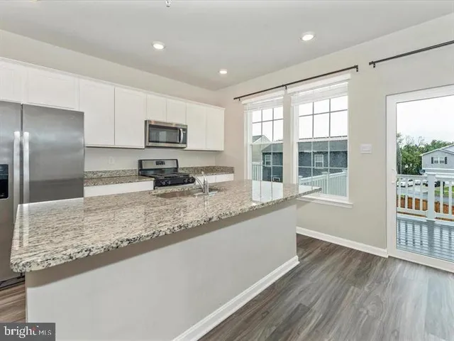 a kitchen with granite countertop a refrigerator and a sink
