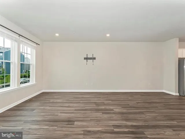 a view of a livingroom with wooden floor and a ceiling fan