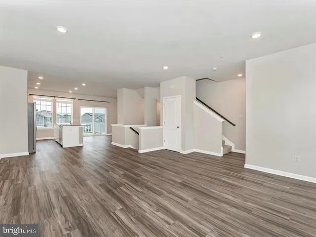 a view of a big room with wooden floor and windows