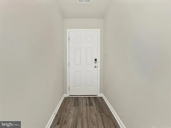 a view of a small space with wooden floor and a window