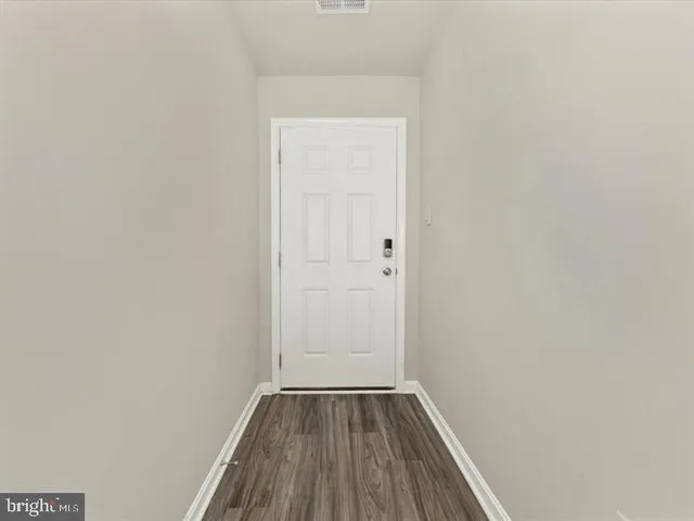 a view of a small space with wooden floor and a window