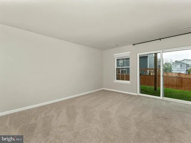 an empty room with floor to ceiling window and an outdoor view