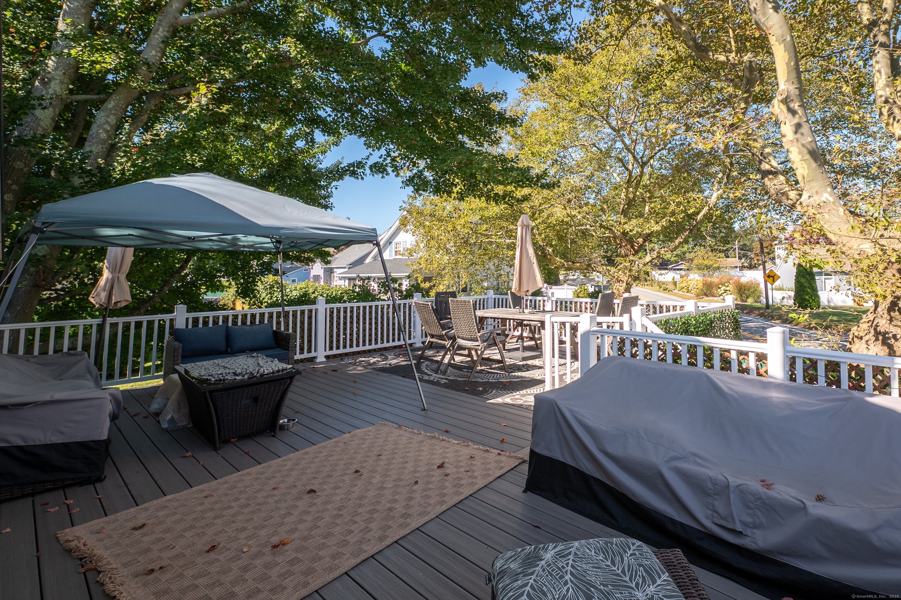 Beach Road Old Saybrook, CT 06475 - Photo 1 of 16 a view of a patio with couches table and chairs under an umbrella with a barbeque