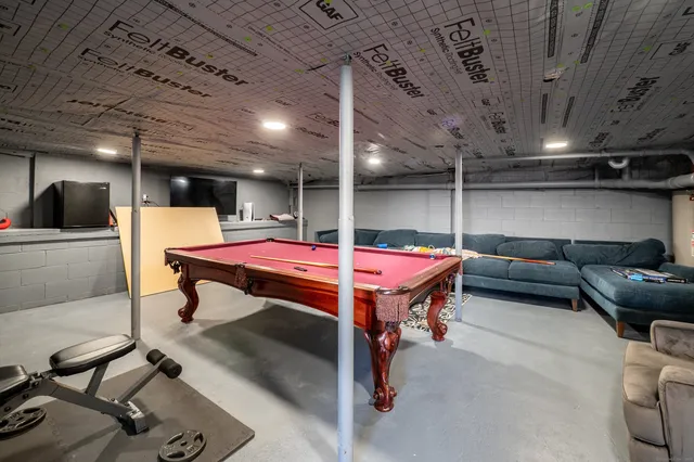 a room with furniture pool table and flat screen tv