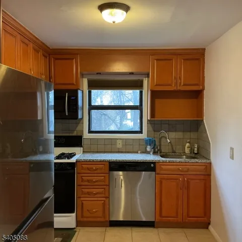 a kitchen with stainless steel appliances granite countertop a sink and a microwave
