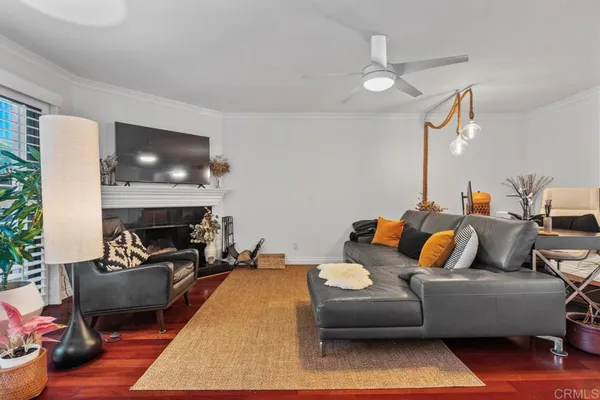 a living room with furniture a window and wooden floor