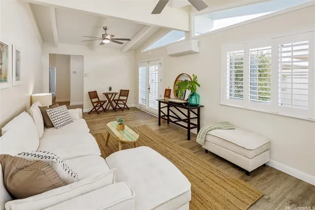 a view of a kitchen with kitchen island a sink wooden floor and counter top space