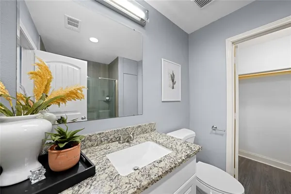 a bathroom with a granite countertop sink and a mirror
