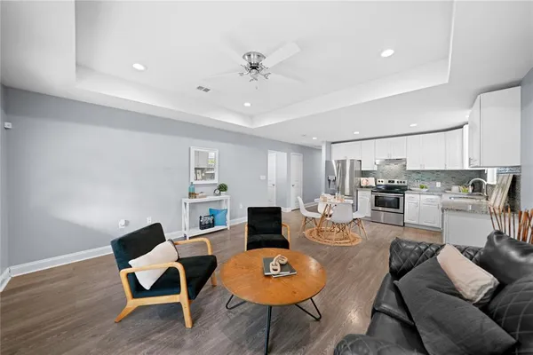 a living room with furniture and a wooden floor