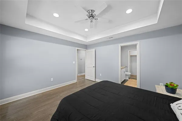 a bedroom with a bed and a chandelier fan