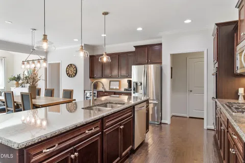 a kitchen with stainless steel appliances granite countertop a sink a stove and a refrigerator